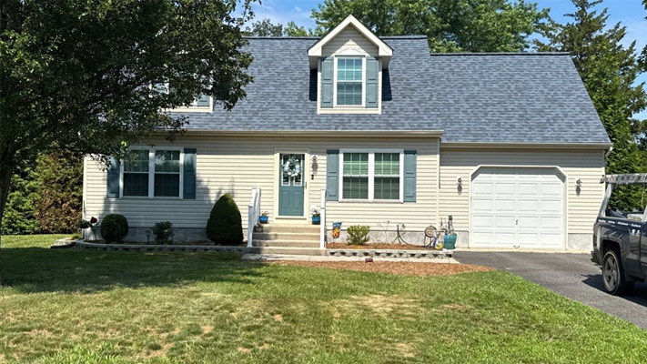 A home with a pitched blue roof in NJ after a completed roof replacement project.